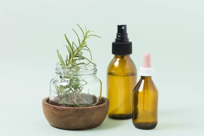 Aroma oils in amber bottles with rosemary